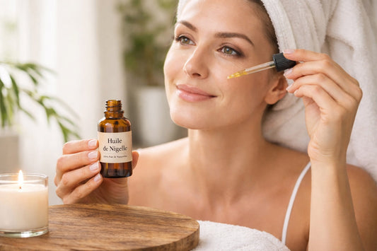 Femme appliquant de l’huile de nigelle sur son visage pour réduire les rides naturellement