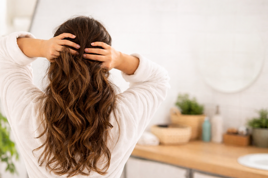 femme cheveux de dos dans salle de bain problème pousse cheveux causes chute et ralentissement cheveux
